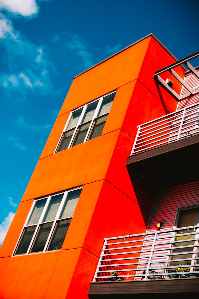how-it-works Low angle of a vibrant orange modern apartment building against a bright blue sky in Eau Claire.
